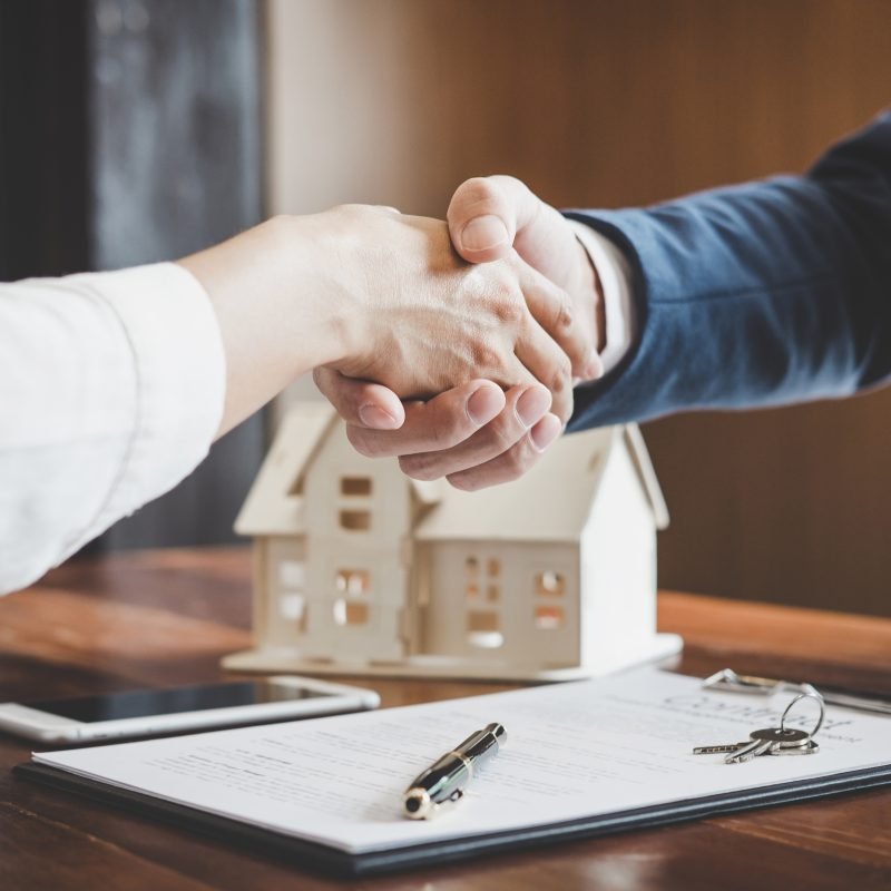 Real estate agent and customers shaking hands together celebrati